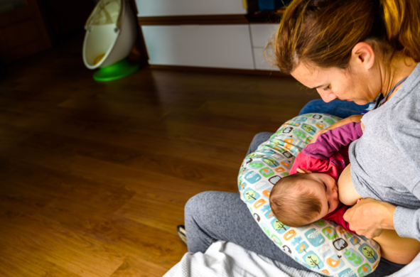 Maman allaitant bébé sur coussin allaitement